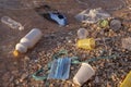 Plastic debris and face masks on the beach in surf zone