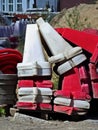 Plastic divider road blocks in white and red are stacked on top of each other.