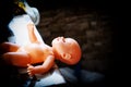 Plastic doll baby toy lies on the kitchen table Royalty Free Stock Photo