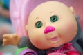 Plastic bald doll with green eyes pink nose Royalty Free Stock Photo