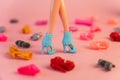 plastic doll legs and house among a variety of colorful shoes. the concept of the development of the cult of consumption in