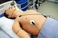 A plastic dummy on a hospital bed with connected life support sensors. Practice and training of young doctors in a medical