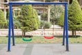 Plastic and Empty red and green chain swings in children playground. chain swings hanging in garden . Childs swing in a park