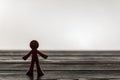 Plastic figure of a man standing lonely on a wooden table