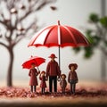 Plastic figures in the form of a family protected by a red umbrella. Insurance concept