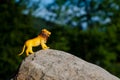 Plastic figurine of a toy lion on a stone