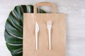 Plastic fork, knife on paper bag. Eco-friendly food packaging and cotton eco bags on gray background with copy space Royalty Free Stock Photo