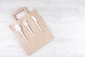 Plastic fork, spoon, knife on paper bag. Eco-friendly food packaging and cotton eco bags on gray background with copy Royalty Free Stock Photo