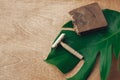 Plastic free beauty essentials. Natural eco soap and reusable metal razor on wooden background with green monstera leaf. Zero Royalty Free Stock Photo