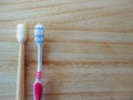 Plastic free lifestyle swap concept with a plastic toothbrush and a bamboo toothbrush as sustainable alternative on a wooden