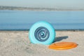 Plastic frisbee discs on sandy beach near river