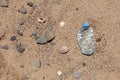 Plastic garbage on the beach. Single-use plastic bottle thrown by sea wave on shore. Concept - Pollution of world ocean by