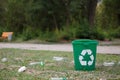 Bright recycling bin next to plastic bottles on a natural background. Containers for rubbish recycling. Environment Royalty Free Stock Photo