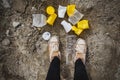 Plastic garbage underfoot.Crumpled disposable plastic glasses in yellow and white lie on the ground. The concept of an