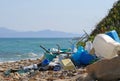 Plastic garbage and wastes on the beach with the sea and an island on background Royalty Free Stock Photo