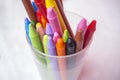 Plastic glass full of used wax crayons Royalty Free Stock Photo