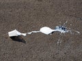 Plastic glass with ice cream overturned on the asphalt on the street on a sunny day Royalty Free Stock Photo