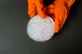 Plastic granules . Polyethylene pellets and hands with orange gloves. Quality control of plastic in the laboratory in production.