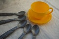 Plastic gray toy spoons and a yellow cup Royalty Free Stock Photo