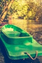 Plastic green boat and calm river with bamboo trees on nature ba