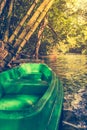 Plastic green boat and calm river with bamboo trees on nature ba