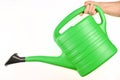 Plastic green watering can for plants in hand isolated on white. Royalty Free Stock Photo