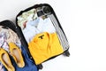 Plastic hardshell suitcase packed with casual clothing items