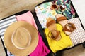 Plastic hardshell suitcase packed with casual clothing items