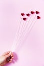 Plastic hearts on a pink background as a cluster of ballon, holding by a woman`s hand. Royalty Free Stock Photo