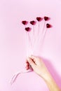 Plastic hearts on a pink background as a cluster of ballon, holding by a woman`s hand. Royalty Free Stock Photo