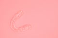 Plastic impression of teeth. Orthodontic silicone trainer. Mobile orthodontic appliance for dental correction, on pink