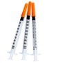 Plastic insulin syringes for diabetes. Needle for addict. Three insulin syringes with orange cover isolated on white background.