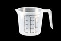 Plastic kitchen measuring cup on isolated black background. Close-up Royalty Free Stock Photo