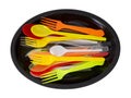 Plastic knives, forks and spoons on black plate isolated on white. Royalty Free Stock Photo