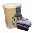 Plastic laundry basket, from under the lid of which are half stuck striped knee socks and a stack of clothes next to the floor Royalty Free Stock Photo