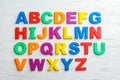 Plastic magnetic letters on wooden background, top view.