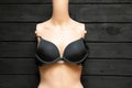a plastic mannequin with a black female bra lies on a wooden table, female Royalty Free Stock Photo