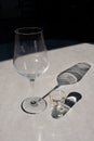Plastic marble imitation table in restaurant terrace after dinner with empty wine glass and empty appetizer shadows
