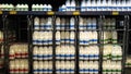 Plastic milk bottles of whole, semi and skimmed milk for sale in a supermarket chiller