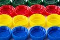 Plastic multi-colored bottle caps are arranged in rows on a white background Royalty Free Stock Photo