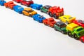 Plastic multi-colored toy cars are lined up on a white background. Stereotypical alignment of subjects is a sign of autism.