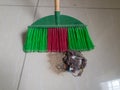 A plastic multicolor broom on tile floor