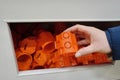 Plastic orange detail the power socket. AC power outlet device. A woman holds an orange plastic part of the outlet in her hand