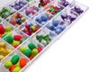 Plastic organizer with different beads on white background. Space for text Royalty Free Stock Photo