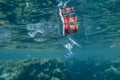 Plastic and other debris floats underwater in blue water. Plastic garbage polluting seas and ocean Royalty Free Stock Photo