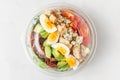 Plastic package with healthy cobb salad with chicken, avocado, bacon, blue cheese, tomatoes and eggs to take away Royalty Free Stock Photo