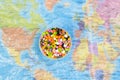 Plastic pellets on the background of the world map in a plastic film. Plastic pollution. The concept of world environment day. Royalty Free Stock Photo