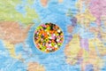Plastic pellets on the background of the world map in a plastic film. Plastic pollution. The concept of world environment day. Royalty Free Stock Photo