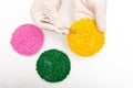 Plastic pellets . Colorant for polymers in granules. Worker wearing gloves takes plastic pellets with tweezers Royalty Free Stock Photo