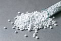 Plastic pellets. White Colorant for plastics, in test-tube against a silvery metallic background. Royalty Free Stock Photo